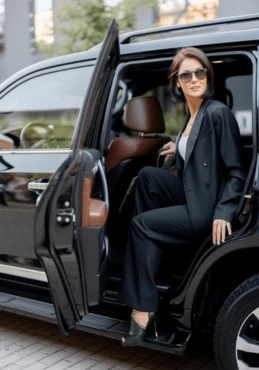 A business woman sitting in a black luxury SUV