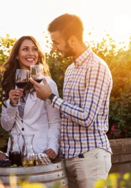 A man and a woman enjoying wine at a winery tour